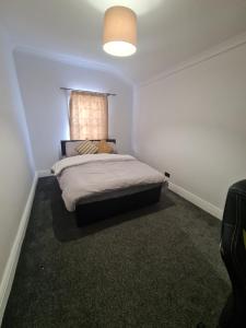 a small bedroom with a bed with a window at The Carnation in Grays Thurrock