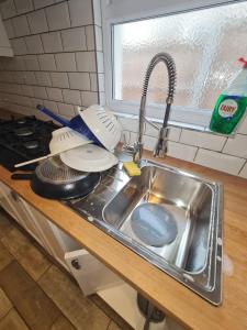 a kitchen counter with a sink with dishes in it at The Carnation in Grays Thurrock +127 photos