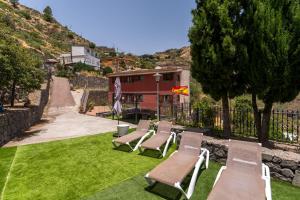 a group of chairs sitting on the grass in a yard at Villa Mogaren in Vega de San Mateo