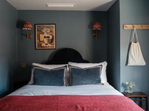 a bedroom with a large bed with blue walls at The Great Decoy in Hurstbourne Tarrant