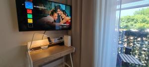 a living room with a tv and a table with a television at Silverka Studio in Tarnowskie Góry
