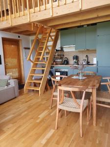 a kitchen and dining room with a wooden table and stairs at Dolina nad Drawa in Przeborowo +29 photos