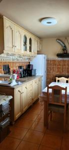a kitchen with wooden cabinets and a white refrigerator at Casa Răzvan in Arieşeni