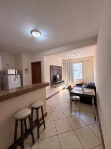 a kitchen and a living room with a table and chairs at Temporada Ilhéus Centro in Ilhéus +10 photos