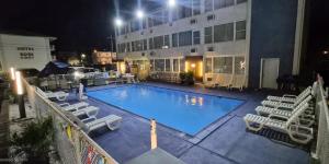 a large swimming pool with chairs and a building at AIRE Hotel North Beach Jersey Shore in Seaside Heights