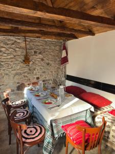 a dining room with a table and chairs and a stone wall at Mark Toma Guesthouse in Shpor