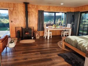 a bedroom with a fireplace and a bed and a table at Fiery Peak Eco-Retreat with Stargazing & Hot tub in Geraldine