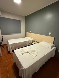 a room with two beds and a chalk board at Bravo City Hotel Campinas in Campinas