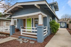 a blue house with a porch with a green door at Le Petite Willow - Guesthouse in Modesto
