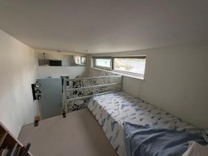 ein kleines Schlafzimmer mit einem Etagenbett und einem Fenster in der Unterkunft Woonboot Adonia in Turnhout