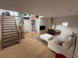 ein Wohnzimmer mit einem weißen Sofa und einem Fernseher in der Unterkunft Woonboot Adonia in Turnhout
