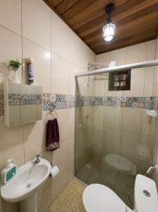 a bathroom with a shower and a sink and a toilet at Chalé Sonho Meu Penedo in Itatiaia +45 photos