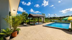 a swimming pool with a gazebo next to a house at Guesthouse AngaLampoe in Lelydorp