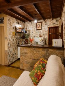 a living room with a couch and a kitchen at Chalé Sonho Meu Penedo in Itatiaia