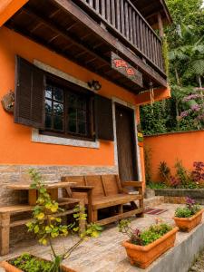 a porch of a house with a wooden table and bench at Chalé Sonho Meu Penedo in Itatiaia