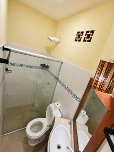 a bathroom with a toilet and a glass shower at Pousada La Cabana in Itacaré +39 photos