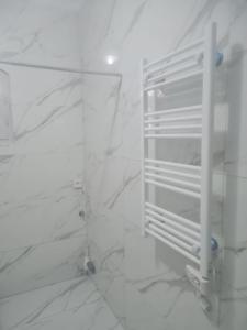 a bathroom with white marble walls and a white refrigerator at Villa FTIMA in Mezraya +25 photos