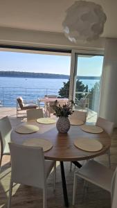 a dining room with a table and a view of the water at OlivaBeachHouse - Direct Waterfront & Mooring in Barbat na Rabu