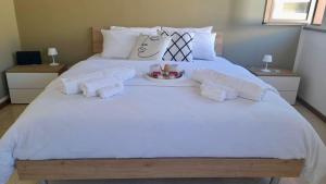 a large white bed with a plate of food on it at Vercelli Civico 31 in Vercelli