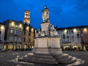 a statue in front of a building with a clock tower at Vercelli Civico 31 in Vercelli