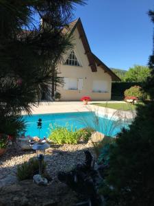 a swimming pool in front of a house at La Petite Provence in Arbois