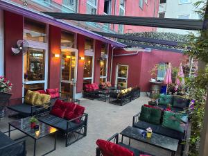 a patio with couches and tables in front of a building at Maxim City Apartment in Mainz