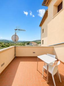 a patio with a white table and chairs on a balcony at Hostal Restaurante Portell in Portell de Morella
