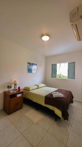 a bedroom with a bed and a table and a window at Aconchego e praticidade no centro histórico in Itu