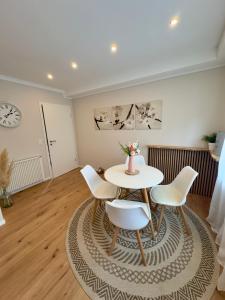 a dining room with a table and chairs and a clock at Ferienwohnung Stefan in Wallertheim