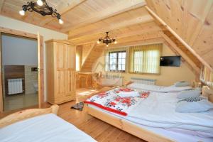 um quarto com 2 camas numa casa de madeira em Przystań w Rzepiskach em Rzepiska