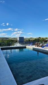 a large swimming pool with blue lounge chairs at El Palmar in San Antonio de Arredondo