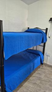 two beds with blue sheets on them in a room at El Palmar in San Antonio de Arredondo