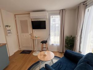 a living room with a blue couch and a table at Cozy & air-conditioned studio in Vannes