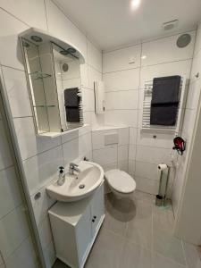 a white bathroom with a sink and a toilet at Ferienwohnung Stefan in Wallertheim +10 photos