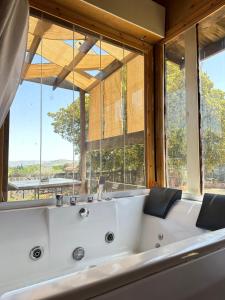 a large white tub in a room with windows at Fashet alsalt in Al Salt
