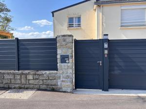 a blue garage door in front of a house at Cozy & air-conditioned studio in Vannes