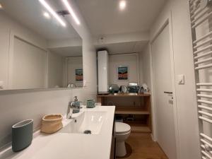 a white bathroom with a sink and a toilet at Cozy & air-conditioned studio in Vannes +3 photos