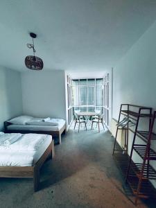 a room with two beds and a table and chairs at Dorey Home DEG1- Business-Apart l vollküche l WLan l Terasse bis 7 Personen in Deggendorf