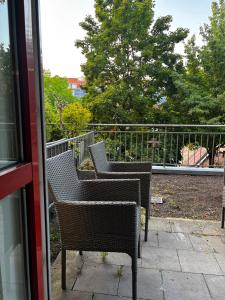 two wicker chairs sitting on top of a balcony at Dorey Home DEG1- Business-Apart l vollküche l WLan l Terasse bis 7 Personen in Deggendorf