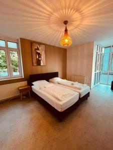 a bedroom with a large bed and a chandelier at Dorey Home DEG1- Business-Apart l vollküche l WLan l Terasse bis 7 Personen in Deggendorf