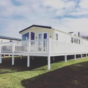 a large white house with a white railing at Craig Tara Beach Lodge in Ayr