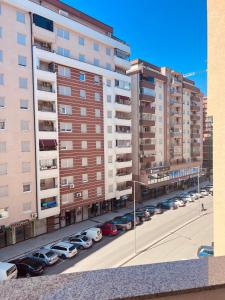 a parking lot with cars parked in front of tall buildings at City View Apartment in Mitrovica