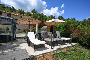 a patio with chairs and umbrellas in a yard at Villa Yari-Dog Friendly, Private Jaccuzzi&Sauna,Shared Infinity Pool, Sea View in Lovran
