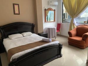 a bedroom with a bed and a chair and a window at Christian Palace in Tena +1 photo