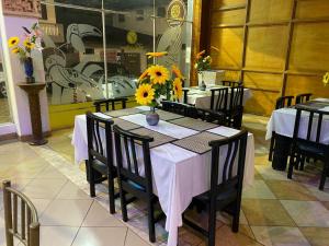 a dining room with a table with sunflowers on it at Christian Palace in Tena