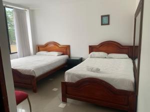 a bedroom with two beds and a red chair at Christian Palace in Tena