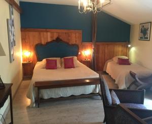 una camera da letto con due letti e un lampadario di Chambres d'Hôtes du Clos Semper Felix a Sainte-Bazeille