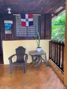 a chair and a table and a flag on a porch at Quisqueya in Arroyo Chico Arriba