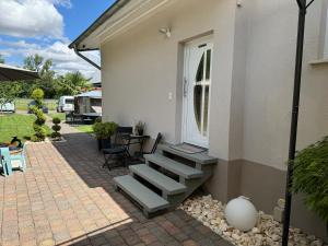 a patio with stairs next to a white house at Ferienwohnung Stefan in Wallertheim