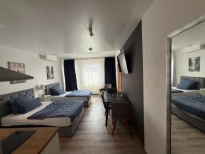 a hotel room with three beds and a desk at Maxim City Apartment in Mainz